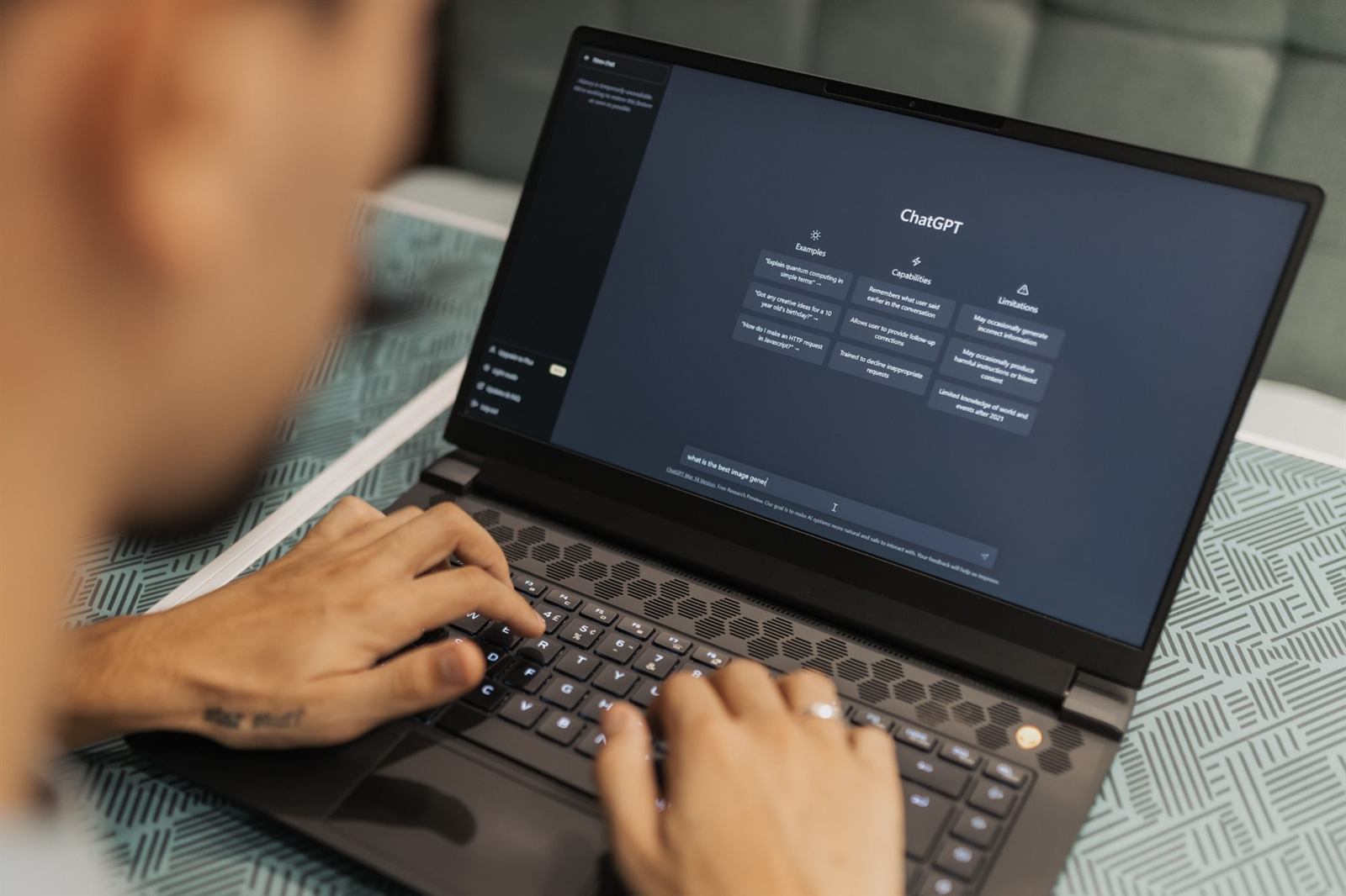 Someone typing a prompt into ChatGPT on a laptop at work